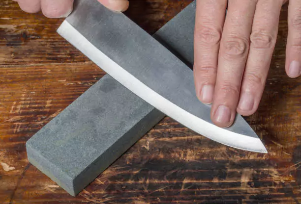 sharpening a chef knife on a whetstone