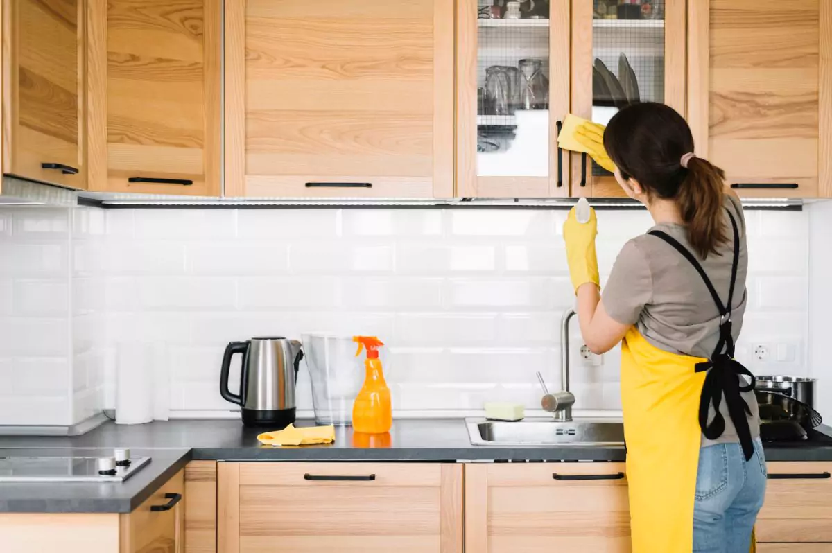 a woman cleaning a kitchen/weekly kitchen cleaning checklist