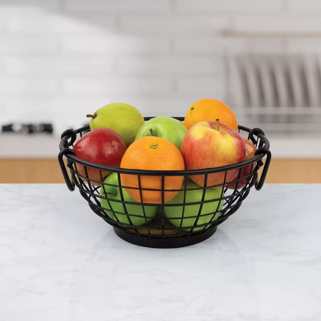 a close look of a fruit bowl with fruits displayed on a counter
