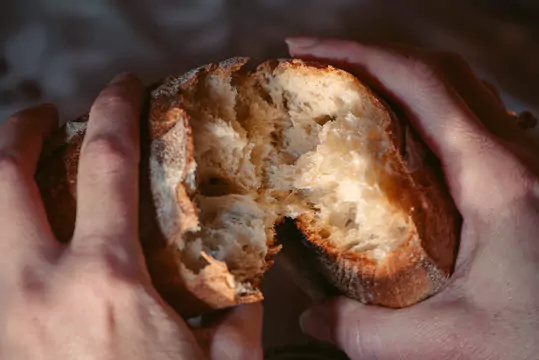 a person breaking bread with his hands