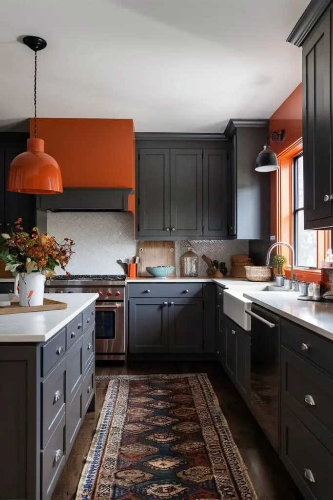 A bold kitchen featuring the burnt orange and charcoal gray color combination. Charcoal gray cabinets are accented with burnt orange walls and decor items, creating a warm and dynamic space.