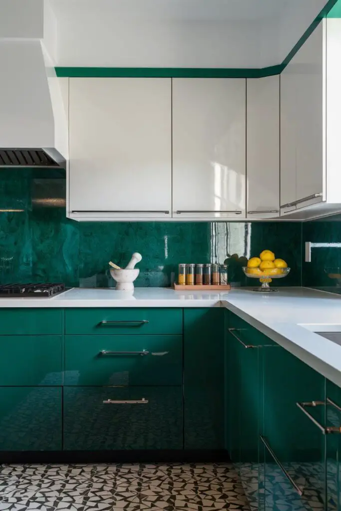 The image depicts a vibrant kitchen with a striking emerald green and white color combination, creating a bold and fresh ambiance. The lower cabinets are painted in a rich, deep emerald green, their glossy finish catching the light and adding a luxurious feel to the space. The cabinets have contemporary, flat-panel doors with sleek, brushed nickel handles that contrast beautifully with the green.

Above the emerald cabinets, the countertops are a clean, crisp white. Their smooth, polished surface provides a bright and fresh look, reflecting light and enhancing the kitchen's sense of openness. The countertops are accessorized with a few stylish items: a marble mortar and pestle, a glass jar filled with bright yellow lemons, and a small wooden tray holding neatly arranged spices.

The backsplash is a standout feature, made up of glossy white subway tiles. These tiles are laid in a herringbone pattern, adding a touch of sophistication and visual interest to the kitchen. The white grout between the tiles emphasizes the intricate pattern, while the high-gloss finish of the tiles bounces light around the room.

Above the backsplash, open shelving in the same emerald green as the cabinets showcases a mix of white dishware and decorative items, such as a few potted herbs in terracotta pots and a set of vintage glass bottles. These shelves add both functionality and style, making the kitchen feel more personalized and inviting.

The floor is a light, natural wood that grounds the bold green and white color scheme with its warm, earthy tones. It adds a touch of rustic charm to the otherwise modern kitchen. 

The kitchen is well-lit with a combination of natural light from a large window and stylish pendant lights hanging over a central island. The pendant lights have clear glass shades with exposed filament bulbs, providing a contemporary industrial touch. The island itself features the same emerald green cabinetry and a white countertop, echoing the color scheme of the rest of the kitchen. Around the island, a few bar stools with white seats and emerald green legs offer a cozy spot for casual dining or socializing.

Overall, the kitchen exudes vibrancy and elegance, with the emerald green and white combination creating a fresh, invigorating space that feels both stylish and welcoming.
Above the emerald cabinets, the countertops are a clean, crisp white. Their smooth, polished surface provides a bright and fresh look, reflecting light and enhancing the kitchen's sense of openness. The countertops are accessorized with a few stylish items: a marble mortar and pestle, a glass jar filled with bright yellow lemons, and a small wooden tray holding neatly arranged spices.

The backsplash is a standout feature, made up of glossy white subway tiles. These tiles are laid in a herringbone pattern, adding a touch of sophistication and visual interest to the kitchen. The white grout between the tiles emphasizes the intricate pattern, while the high-gloss finish of the tiles bounces light around the room.

Above the backsplash, open shelving in the same emerald green as the cabinets showcases a mix of white dishware and decorative items, such as a few potted herbs in terracotta pots and a set of vintage glass bottles. These shelves add both functionality and style, making the kitchen feel more personalized and inviting.

The floor is a light, natural wood that grounds the bold green and white color scheme with its warm, earthy tones. It adds a touch of rustic charm to the otherwise modern kitchen. 

The kitchen is well-lit with a combination of natural light from a large window and stylish pendant lights hanging over a central island. The pendant lights have clear glass shades with exposed filament bulbs, providing a contemporary industrial touch. The island itself features the same emerald green cabinetry and a white countertop, echoing the color scheme of the rest of the kitchen. Around the island, a few bar sto