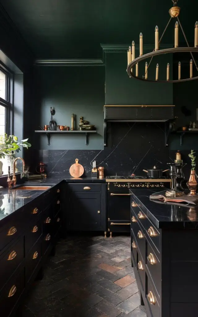 A witchy kitchen with dark, moody colors featuring black cabinets, deep emerald green walls, and brass accents. The countertops are sleek black marble, while a large vintage chandelier with candle-like bulbs hangs above. Copper cookware and utensils add a warm glow to the space.