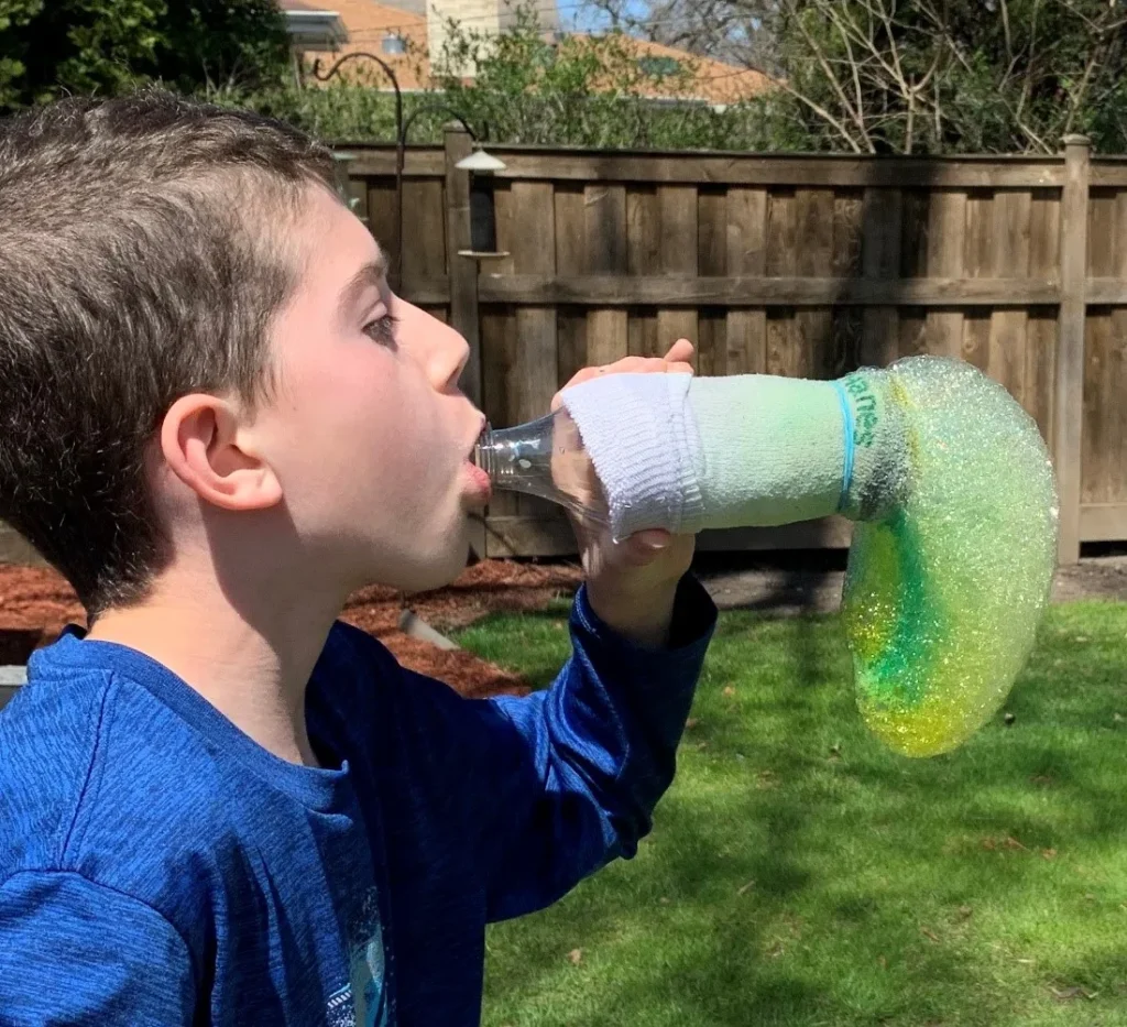 boy using rainbow bubble snake maker